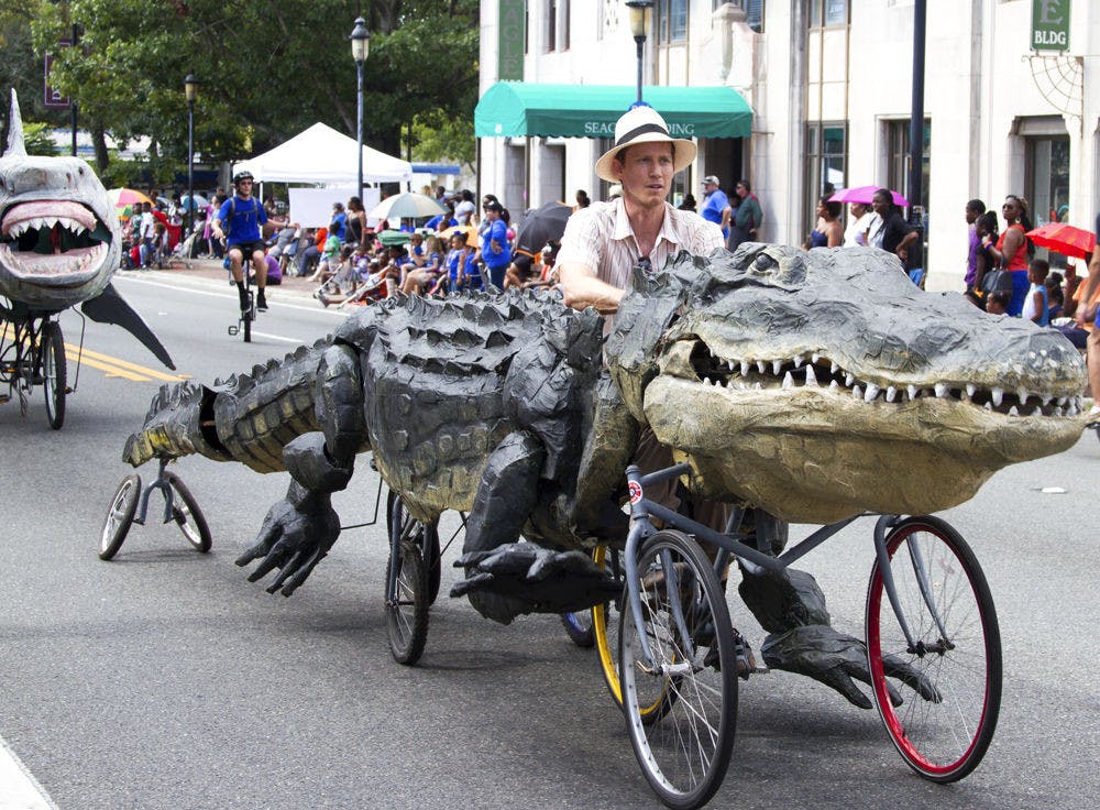 <p>Raymond Rawls rides one of his custom-made floats down University Avenue during the UF Homecoming Parade on Nov. 6, 2015. Of his five creations that will be featured at the Menagerie in Motion event on Saturday, Rawls said the alligator his favorite.</p>