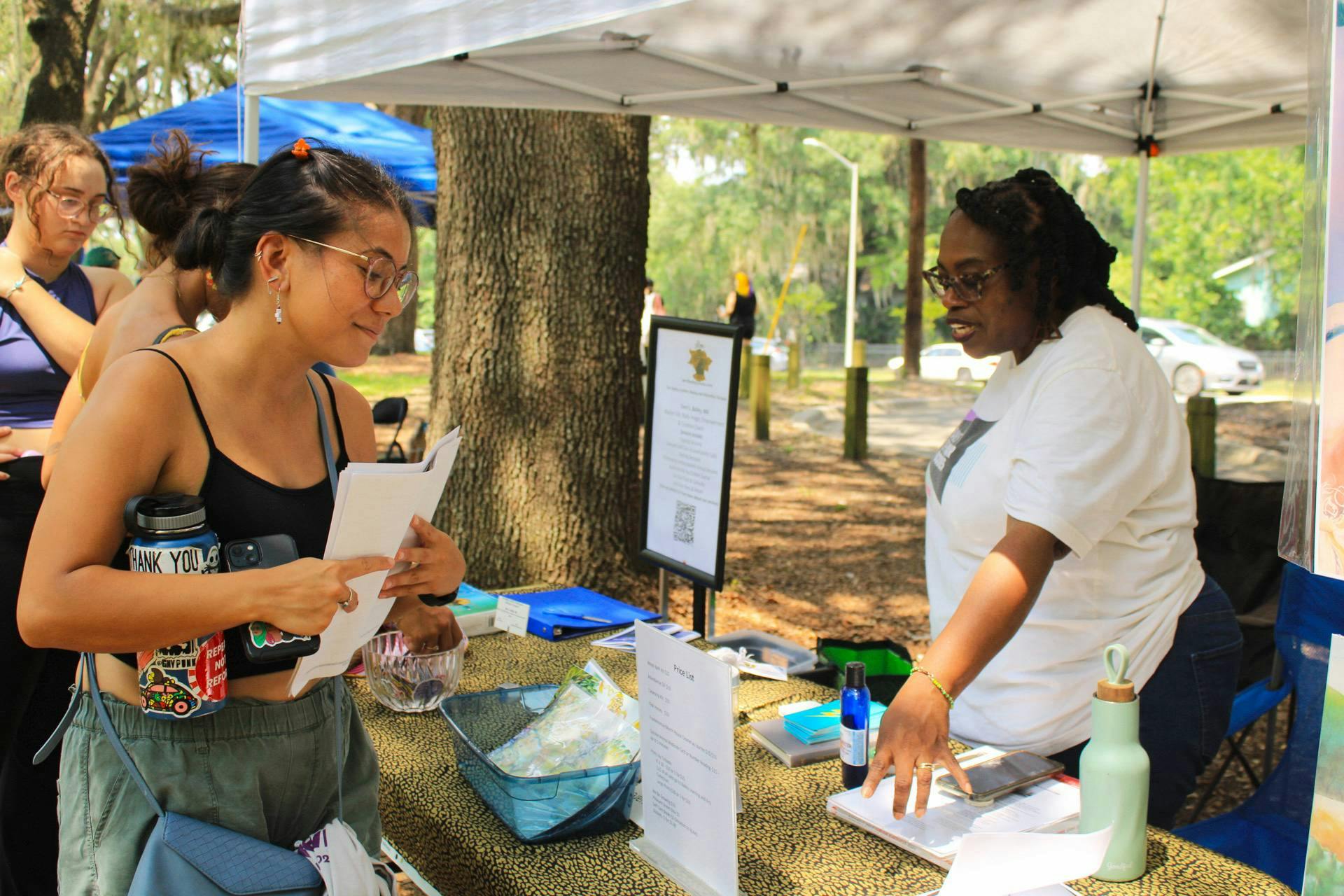 Terri Bailey, activist and owner of Bailey Learning and Arts Collective, explains her range of services to visitors at the Cora. P. Roberson park on Saturday, July 1, 2023. 