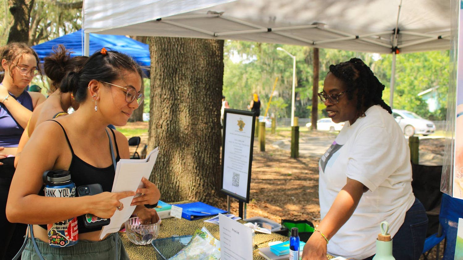 Terri Bailey, activist and owner of Bailey Learning and Arts Collective, explains her range of services to visitors at the Cora. P. Roberson park on Saturday, July 1, 2023. 