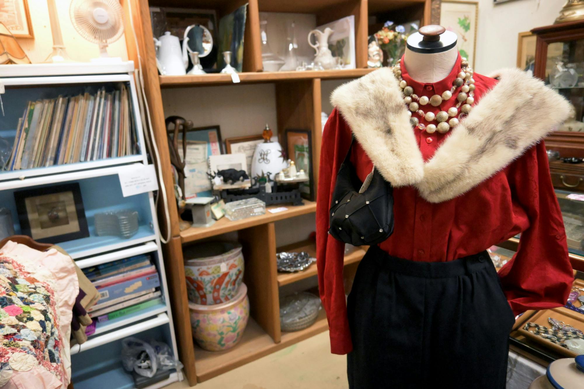 A vibrant red blouse is adorned with a brown fur shawl at Antique Emporium on Sunday, May 25, 2025. 
