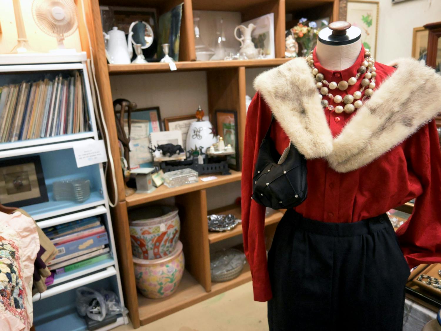 A vibrant red blouse is adorned with a brown fur shawl at Antique Emporium on Sunday, May 25, 2025.