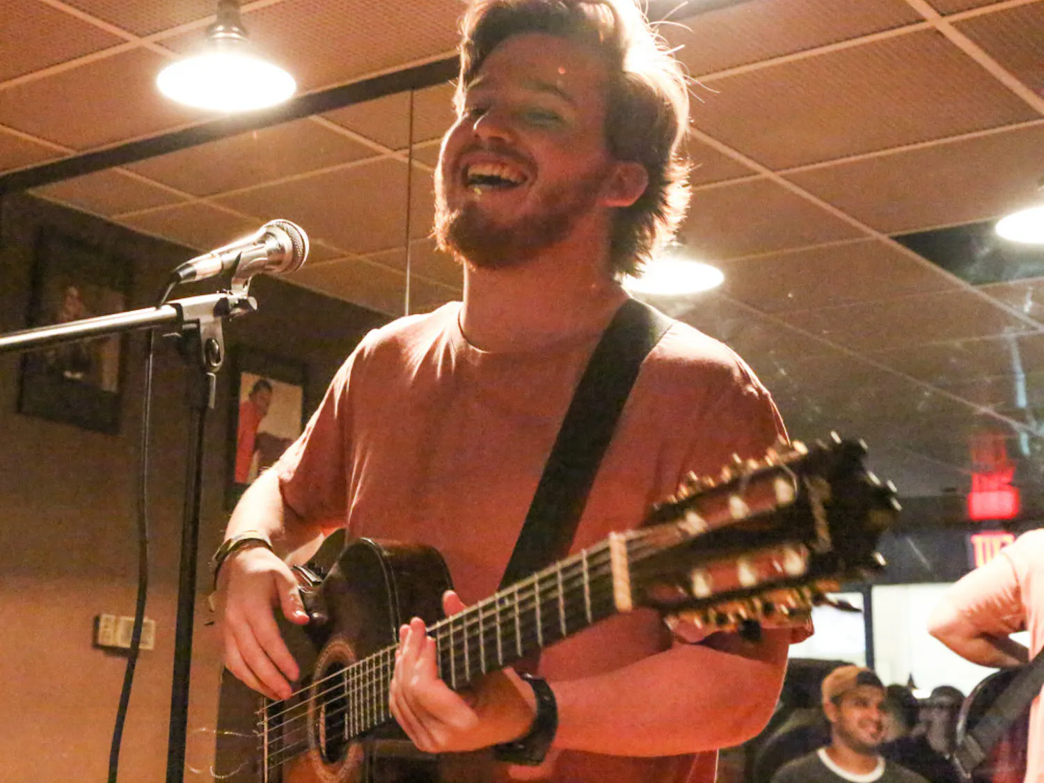 Simon Grossman, a 21-year-old UF telecommunication senior, performs “Te Invito”, a song from his upcoming album at Omi’s Tavern during the open-mic night, which was hosted by Vensa. People donated food and medical supplies to send to Venezuela. See the photo story on page nine.