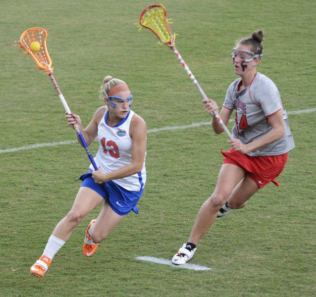 Florida attacker Ashley Bruns (13) runs past Ohio State defender Tayler Kuzma (24) in the Gators’ 13-7 win against the Buckeyes on March 23 at Dizney Stadium. Bruns scored four goals in Florida's 16-5 win against Denver in the second round of the NCAA Tournament.