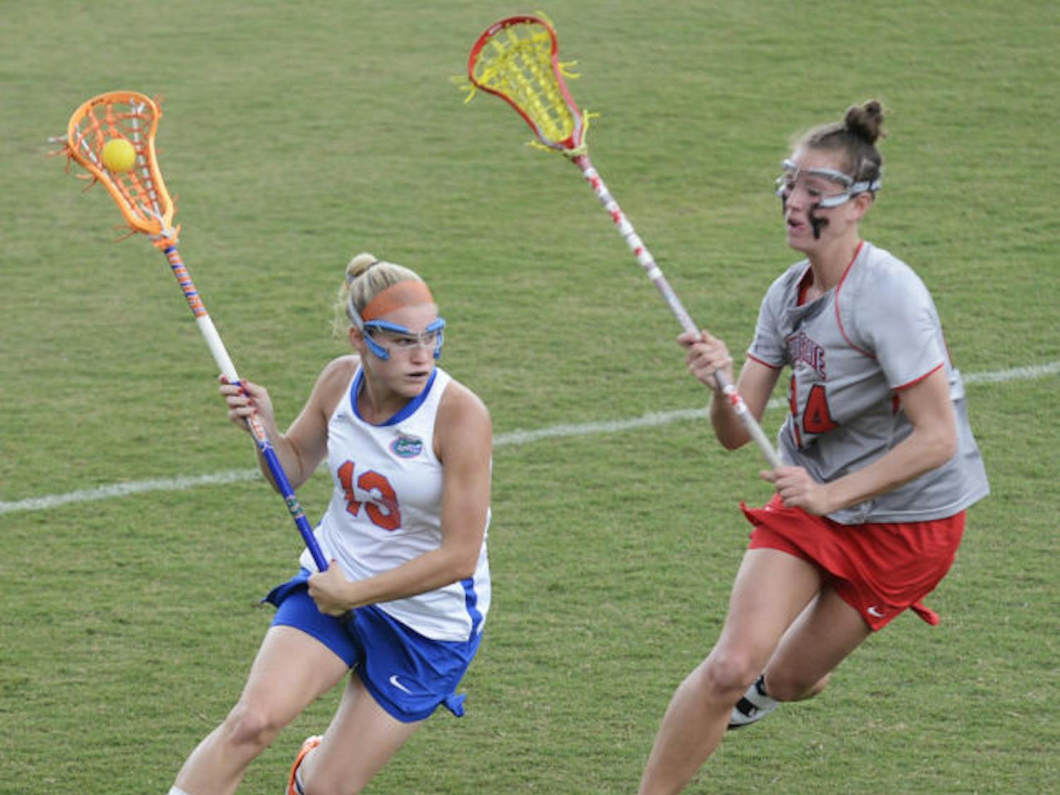 Florida attacker Ashley Bruns (13) runs past Ohio State defender Tayler Kuzma (24) in the Gators’ 13-7 win against the Buckeyes on March 23 at Dizney Stadium. Bruns scored four goals in Florida's 16-5 win against Denver in the second round of the NCAA Tournament.