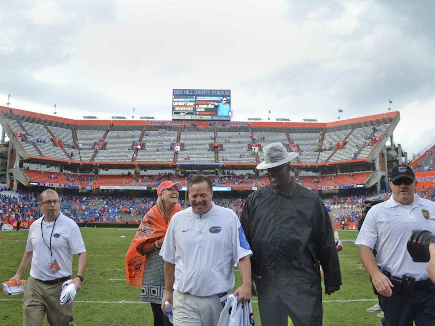 A drenched UF football coach Jim McElwain (center) walks off the field at Ben Hill Griffin Stadium following Florida's 20-14 overtime win against Florida Atlantic on Nov. 21, 2015, at Ben Hill Griffin Stadium.