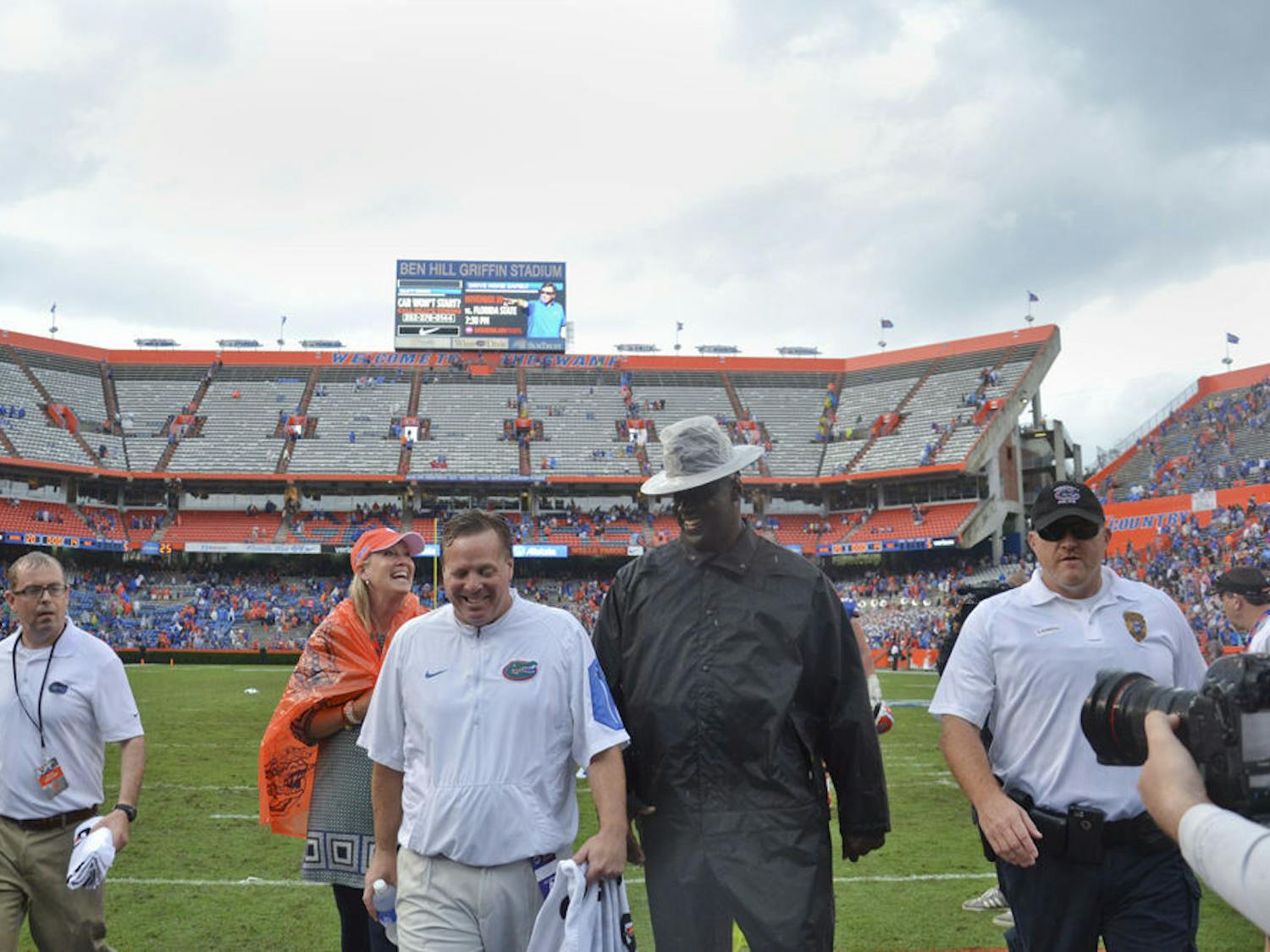 A drenched UF football coach Jim McElwain (center) walks off the field at Ben Hill Griffin Stadium following Florida's 20-14 overtime win against Florida Atlantic on Nov. 21, 2015, at Ben Hill Griffin Stadium.