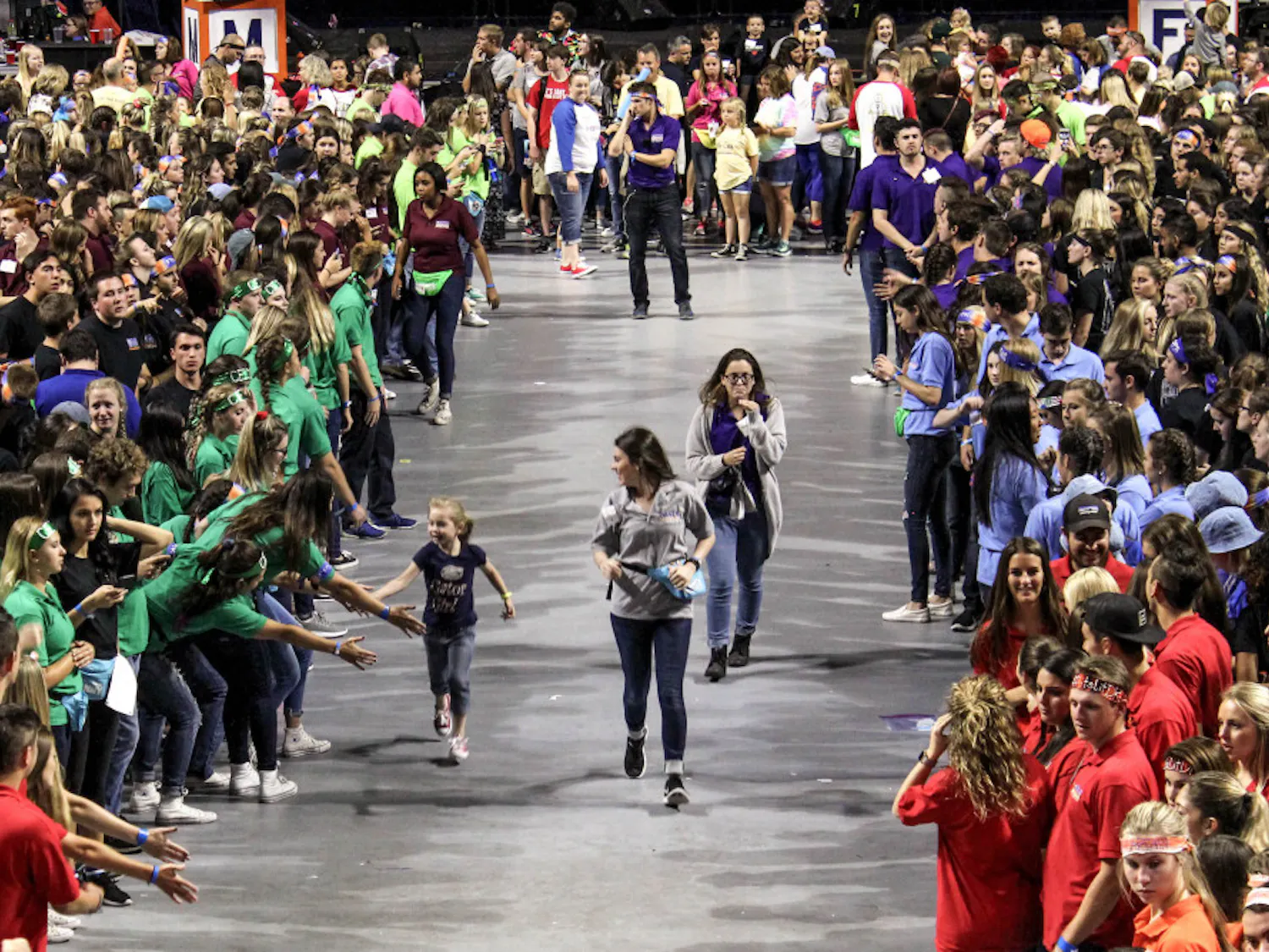 A child runs through the crowd of dancers during Dance Marathon at the O'Connell Center on Sunday. Dance Marathon is an event where volunteers must stay awake and on their feet for 26.2 hours.