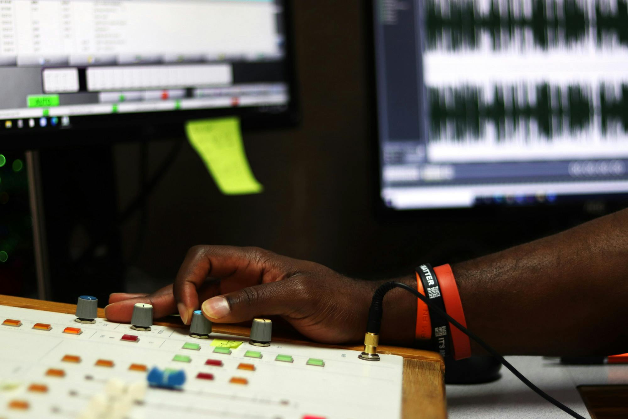 A picture of Ardell Wright adjusts settings on the soundboard in