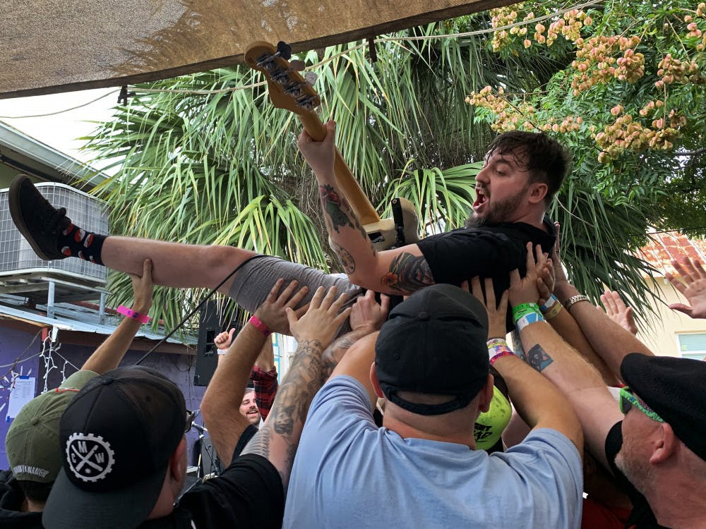 <p>Bobby Edge, vocalist and bass player for the band Jukebox Romantics, crowd surfs during the middle of his set at the Civic Media Center. “Honestly, my favorite thing is seeing all these faces I’ve seen from different countries come here and we all hang out,” Edge said. “Everyone’s in this one central location and it’s f—king amazing.”</p>