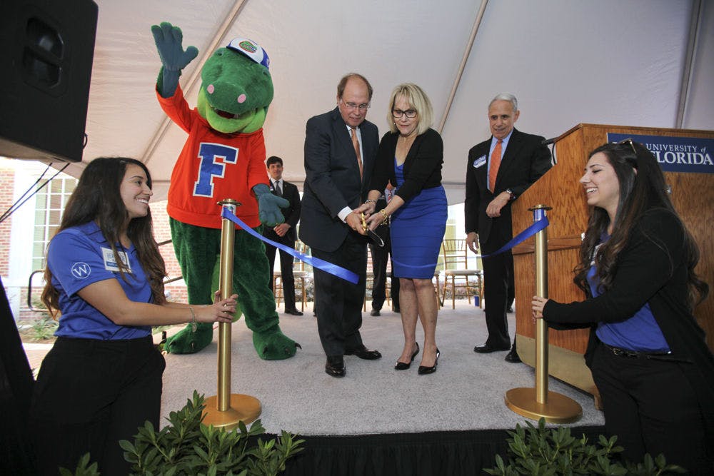 <p class="p1">James “Bill” Heavener and his wife cut a ribbon at the dedication of Heavener Hall on Friday. Heavener, is a 1970 UF business administration alumnus and the building’s lead benefactor.</p>