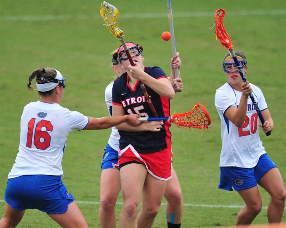 <p>Florida midfielder Nicole Graziano (16) and defender Kayla Stolins (20) attack Detroit midfielder Emily Boissonneault during a 22-3 win on Feb. 26.&nbsp; The Gators are striving for cleaner play as of late.</p>