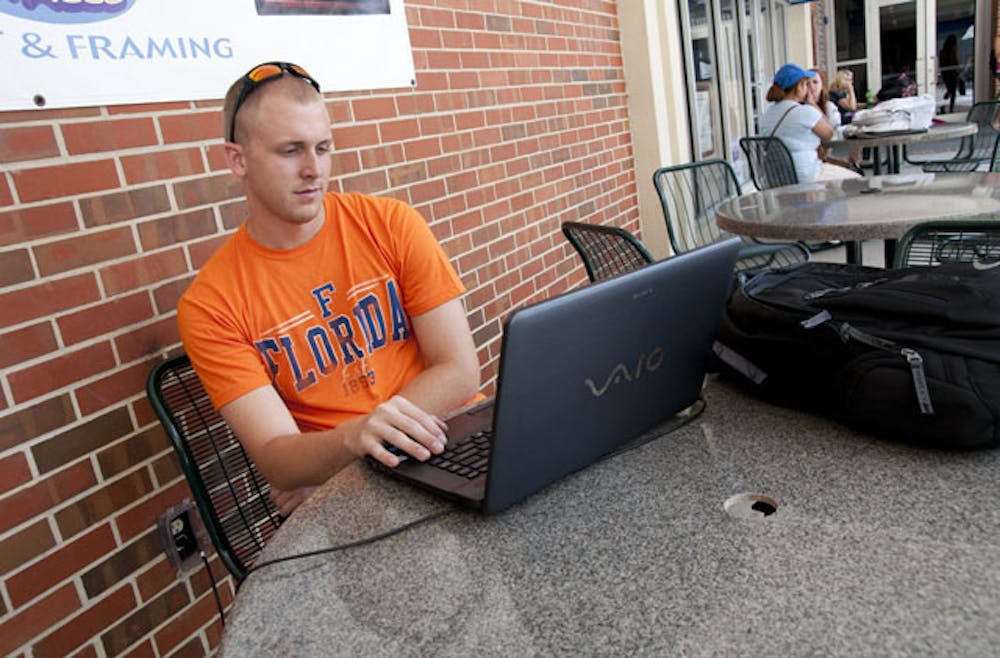 <p>Electrical engineering major Sean Comerford, 22, sets up an online class on his laptop outside of the Reitz Union on Monday afternoon.</p>