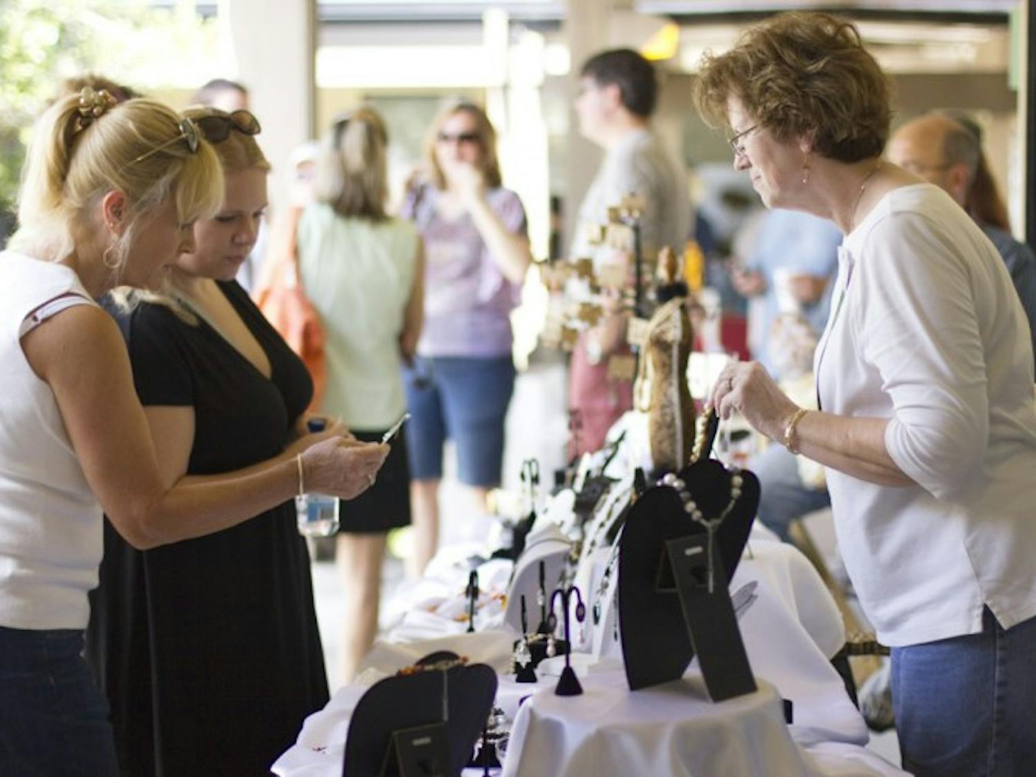 Cathy Martin, 60, owner of Cat's Paw jewelry, talks to festival goers about her jewelry at the Gainesville Fine Arts Association's 28th annual GFAA Art Festival at Thornebrook over the weekend.