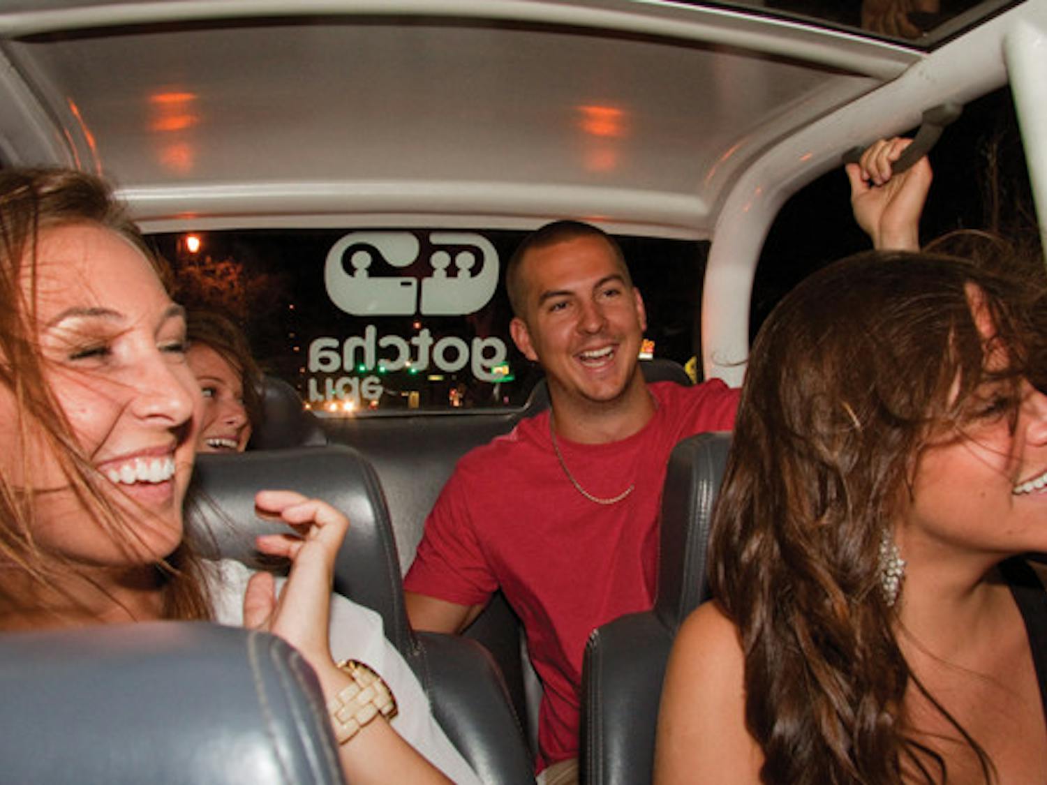 Left to right: Marisa Dunkel, Meagan Kaufman, John Slate and Alison Carestia cruise in a GOTCHA Ride down University Avenue on the way to midtown Wednesday night.