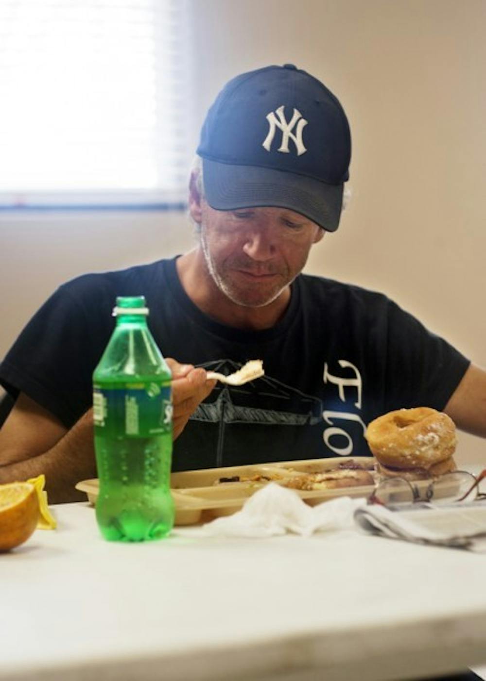 <p>Bob Adams eats at the St. Francis House, 413 S. Main St., on Monday morning. New regulations require people using any service at the shelter and soup kitchen to obtain police clearance.</p>