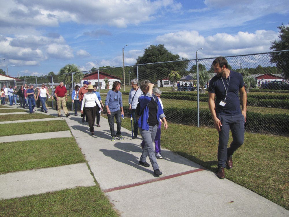 Jon DeCarmine, operations director for the Alachua County Coalition for the Homeless and Hungry, leads a group of visitors on a tour of the 25-acre facility during the shelter’s open house in 2014.&nbsp;