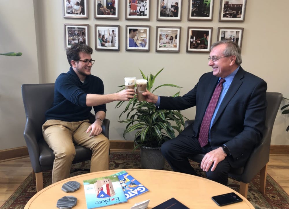 <p>Kyle Cunningham, an Alligator columnist, and UF President Kent Fuchs, who has never had an iced coffee before, enjoy coffee together.</p>
