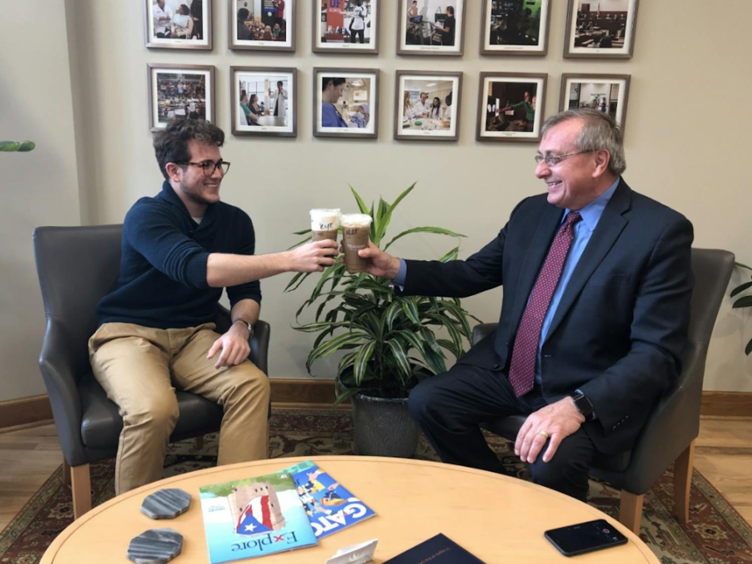 Kyle Cunningham, an Alligator columnist, and UF President Kent Fuchs, who has never had an iced coffee before, enjoy coffee together.