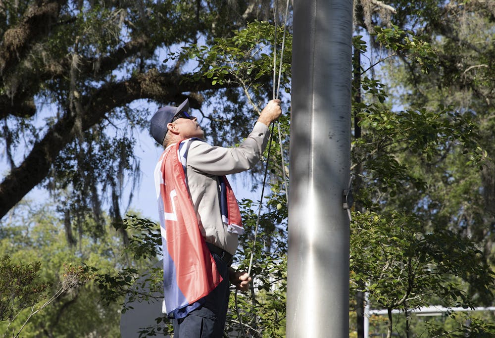 George Cannon, a supervisor of the Gainesville downtown area, raises the Juneteenth flag on Thursday, May 20, 2021.