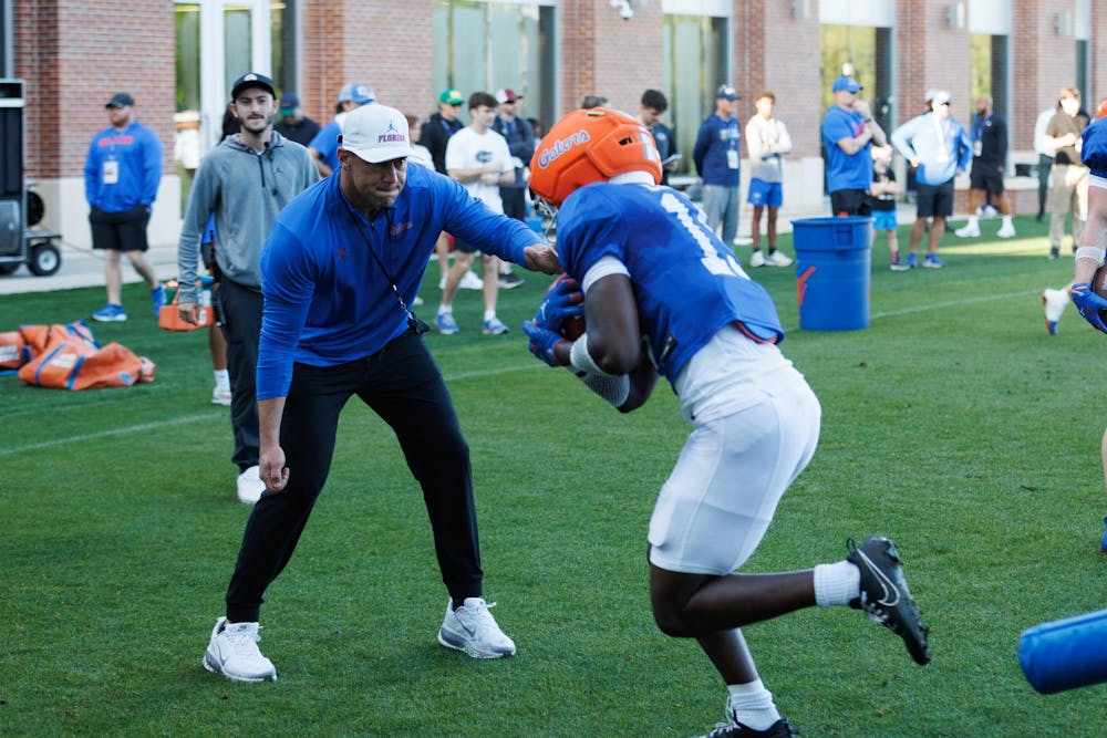 Florida football head coach Jon Sumrall helps with a drill during spring training camp at the Heavener Football Training Center in Gainesville, Fla., Tuesday, March 10, 2026.