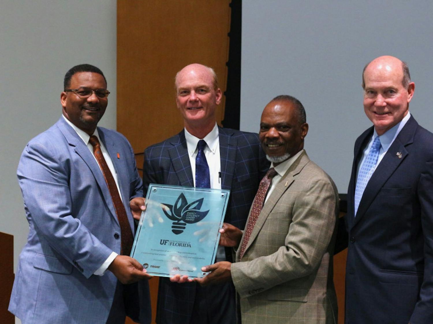 Felix Wilson, the vice president, of Trane’s Southwest and West U.S., presents UF the Trane Energy Efficient Leader Award to Curtis Reynolds, UF’s vice president for business affairs; Eddie Daniels, the assistant vice president for business services; and David Kratzer, a former UF vice president for Student Affairs. The award recognizes the efficient and sustainable approach to the renovation of the Reitz Union.