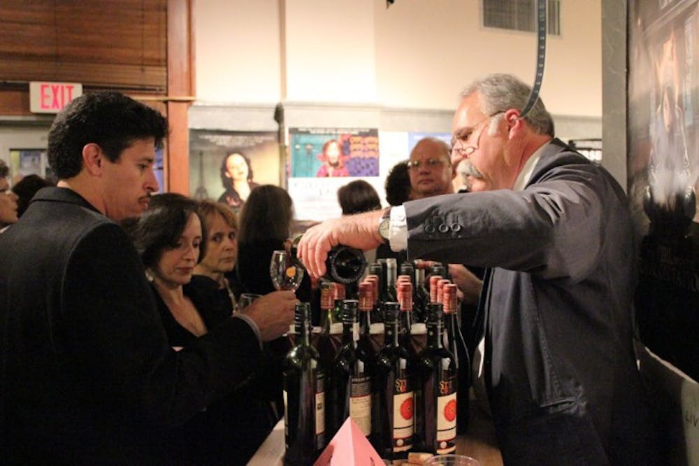 <p>Russell Welker from Tree of Life Wine, right, pours a sample of Merlot for Erik and Marcy Bayard at the Hippodrome's 30th anniversary party on Saturday night.</p>