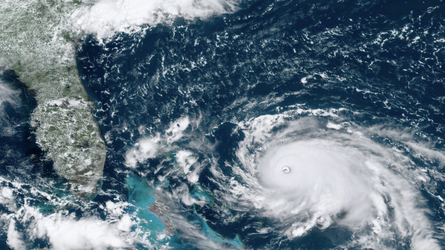 This GOES-16 satellite image taken Saturday, Aug. 31, 2019, at 16:00 UTC and provided by National Oceanic and Atmospheric Administration (NOAA), shows Hurricane Dorian, right, churning over the Atlantic Ocean. Hurricane Dorian bore down on the Bahamas as a fierce Category 4 storm Saturday, with new projections showing it curving upward enough to potentially spare Florida a direct hit but still threatening parts of the Southeast U.S. with powerful winds and rising ocean water that causes what can be deadly flooding.(NOAA via AP)