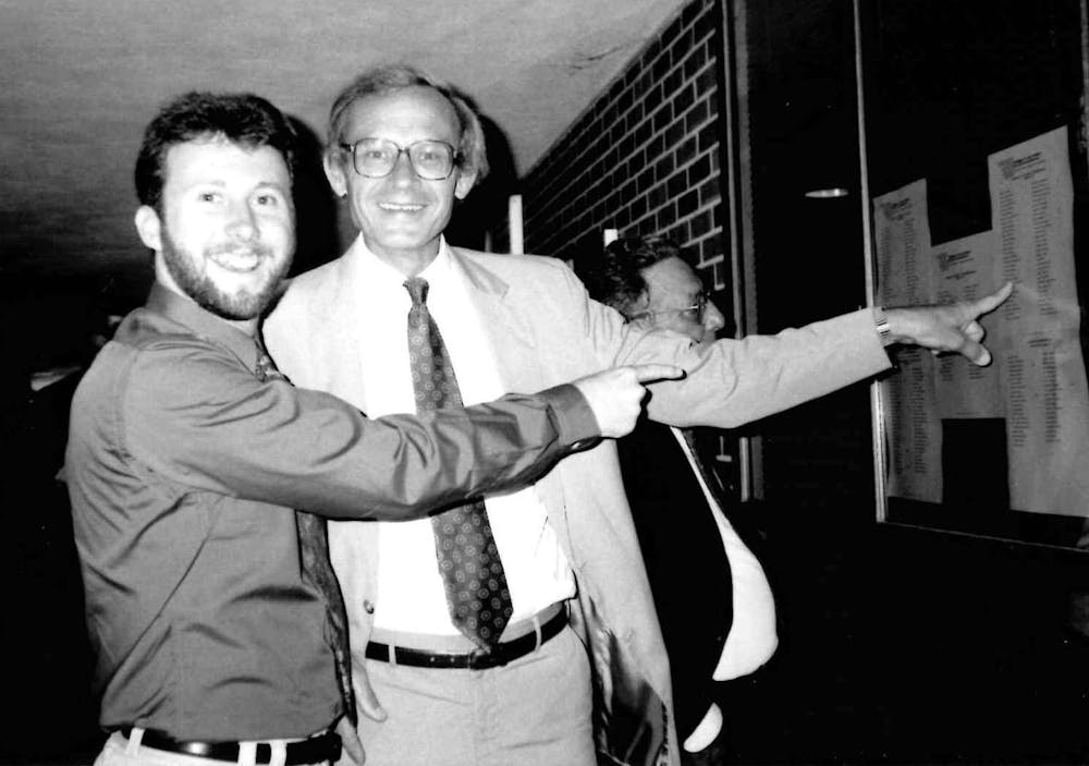 Sam Dolson, left, and Jon Roosenraad look at the list of graduates in Weimer Hall during the 1992 Spring graduation. 