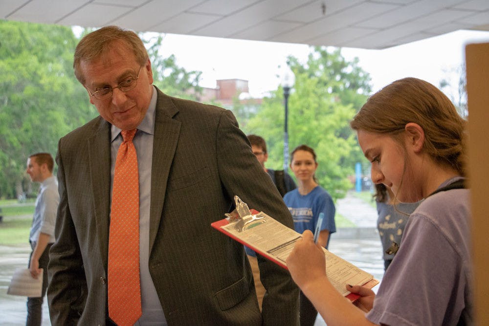 <p>From left: UF President Kent Fuchs assists Natalie Evelev, an 18-year-old UF biomedical engineering freshman, with registering to vote at the Voter Registration Drive with UF President Kent Fuchs and Alachua County Supervisor of Elections Kim Barton outside the Reitz Union on Monday afternoon. Evelev said she wanted to register to vote.</p>
