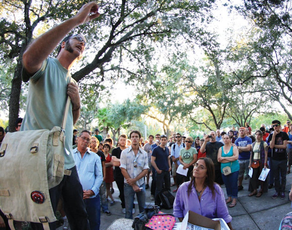 <p>Gainesville activist Jesse Schmidt stands before a crowd of about 120 people as Occupy Gainesville rallies on the steps of City Hall Wednesday evening. Occupy Gainesville is a splinter group of Occupy Wall Street, a movement to "stop corporate greed and corrupt politics," according to occupywallst.org.</p>