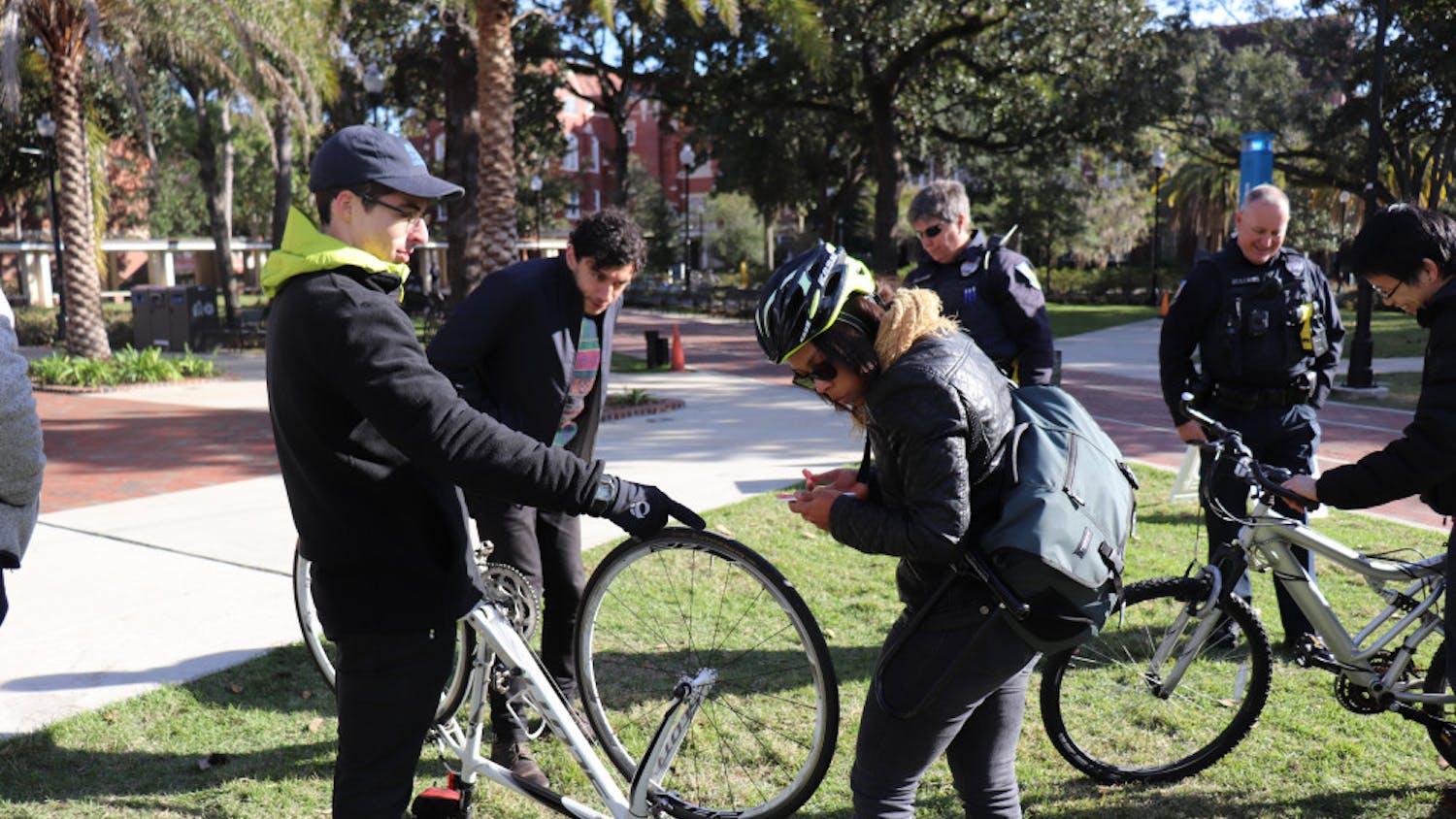 Seth Wood, 23, and Lian Plass, 24, both first-year UF urban and regional planning graduate students, examine Plass’ bike on the Plaza of the Americas Nov. 28 at a “Bike to Campus Day”, that rewarded bicyclists with free food. 