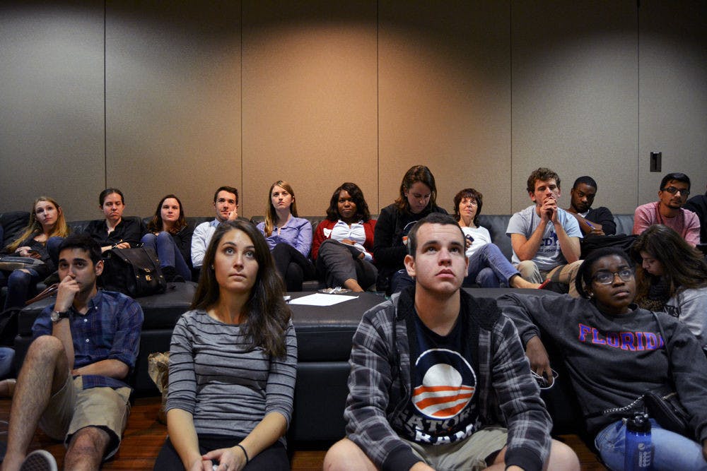 Amir Avin, 20, Jenna Goldman, 21, Joe Andreoli, 23, and Christina Marshall, 19, all UF students, watch President Obama’s State of the Union Address in Murphree Commons at the College Democrats' watch party Tuesday night.