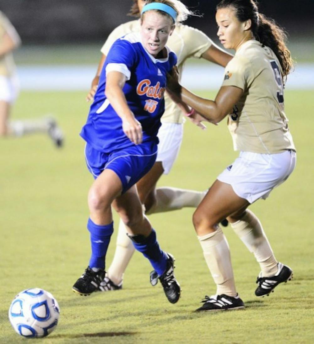 <p>Tessa Andujar (15) moves the ball past Ashleigh Shim (9) during Sundays win against Florida International University at James G. Pressly Stadium.</p>
<p>&nbsp;</p>