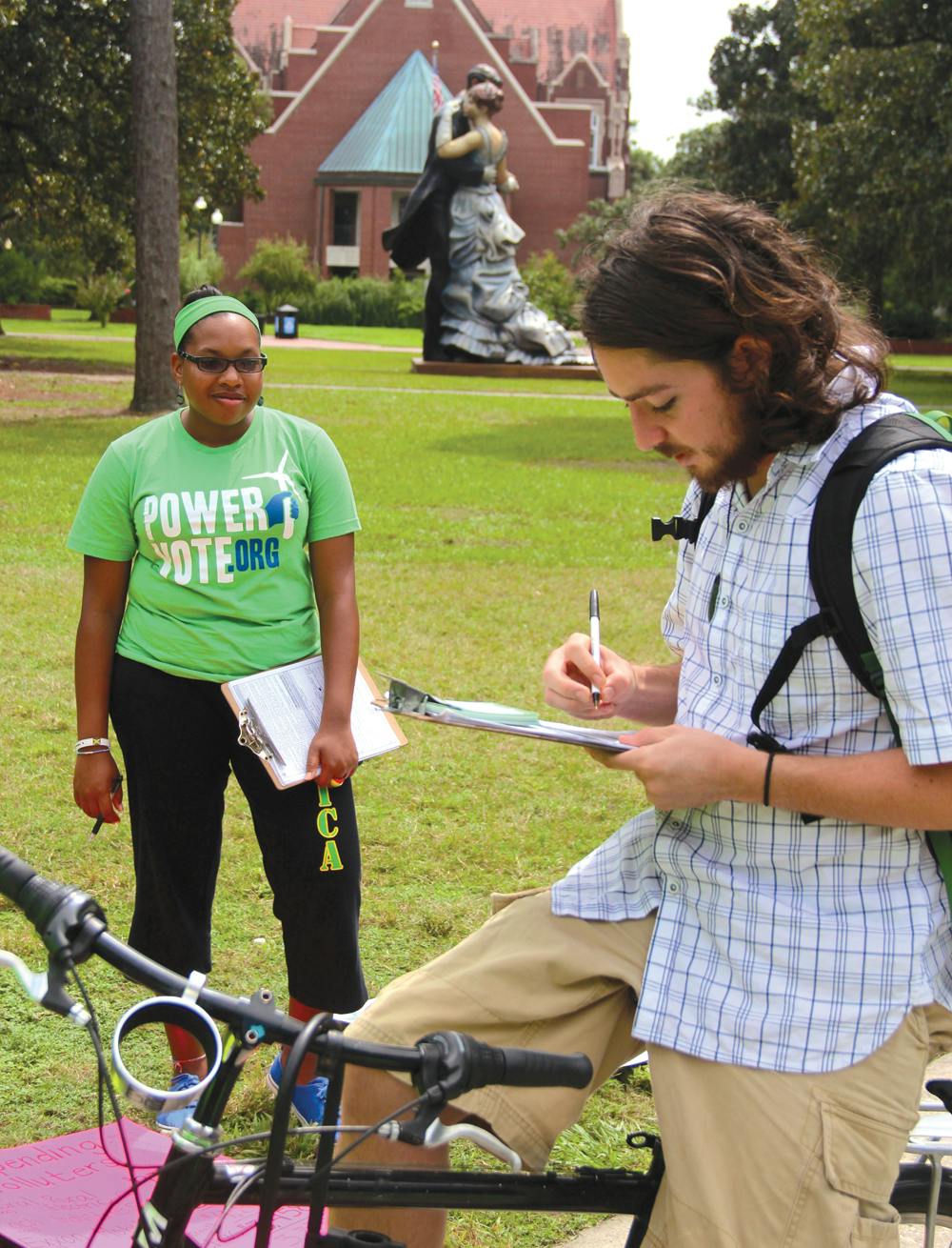Janine Monfries, 21, helps with the Power Vote campaign while Alec Shoelson, 22, fills out a Power Vote pledge card on Thursday.