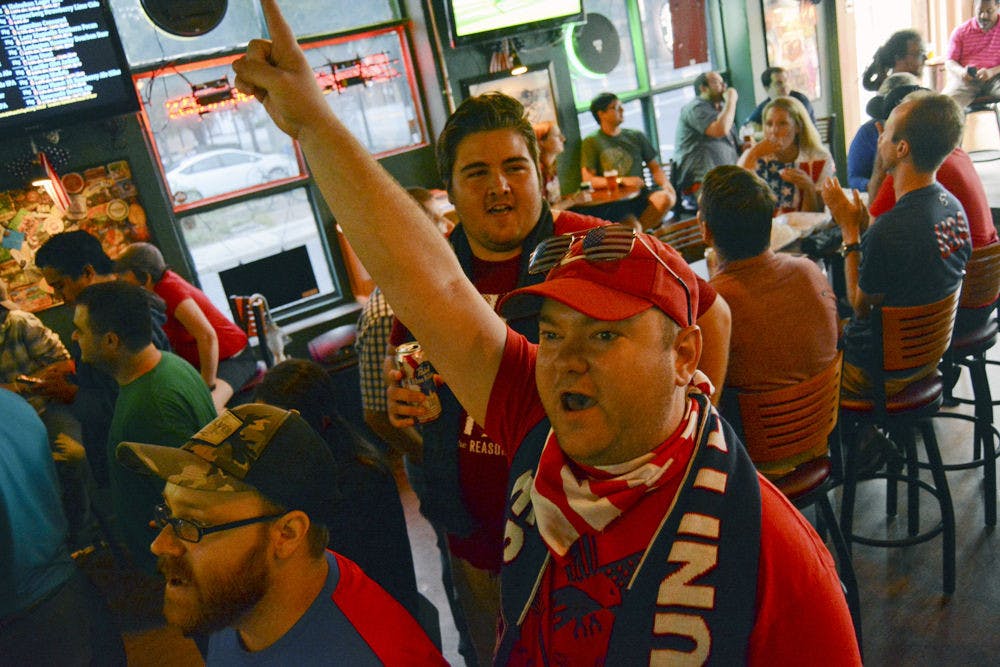 Benjamin Swartz, the 31-year-old vice-president of the Gainesville chapter of American Outlaws, leads a chant supporting the US women's soccer team's 5-2 victory over Japan on Saturday. "We are the US!" chanted fans in Gainesville House of Beers.