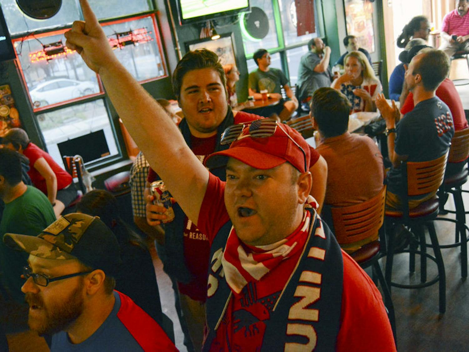 Benjamin Swartz, the 31-year-old vice-president of the Gainesville chapter of American Outlaws, leads a chant supporting the US women's soccer team's 5-2 victory over Japan on Saturday. "We are the US!" chanted fans in Gainesville House of Beers.