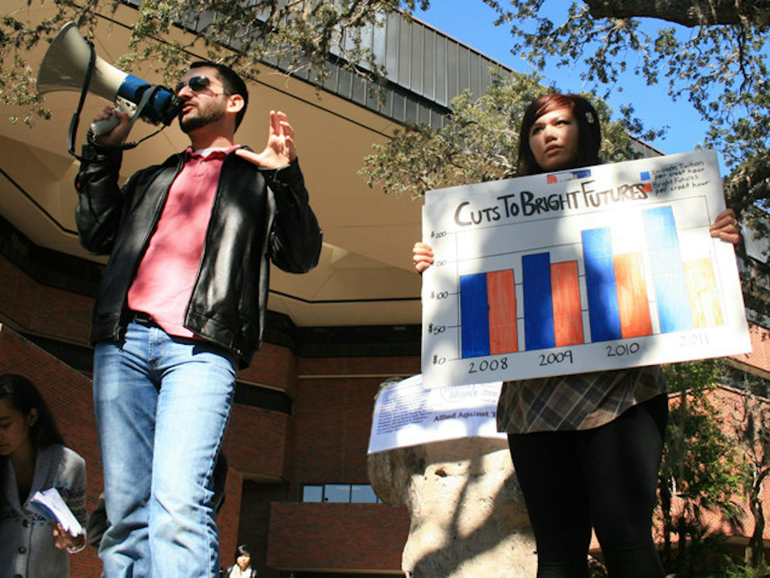Gator Student Alliance members Robbey Hayes, a 20-year-old anthropology junior, and Marie Dino, a 20-year-old education sophomore, educate UF students passing through Turlington Plaza on Wednesday afternoon about the cuts that the state is making in education and how it will affect future tuition.