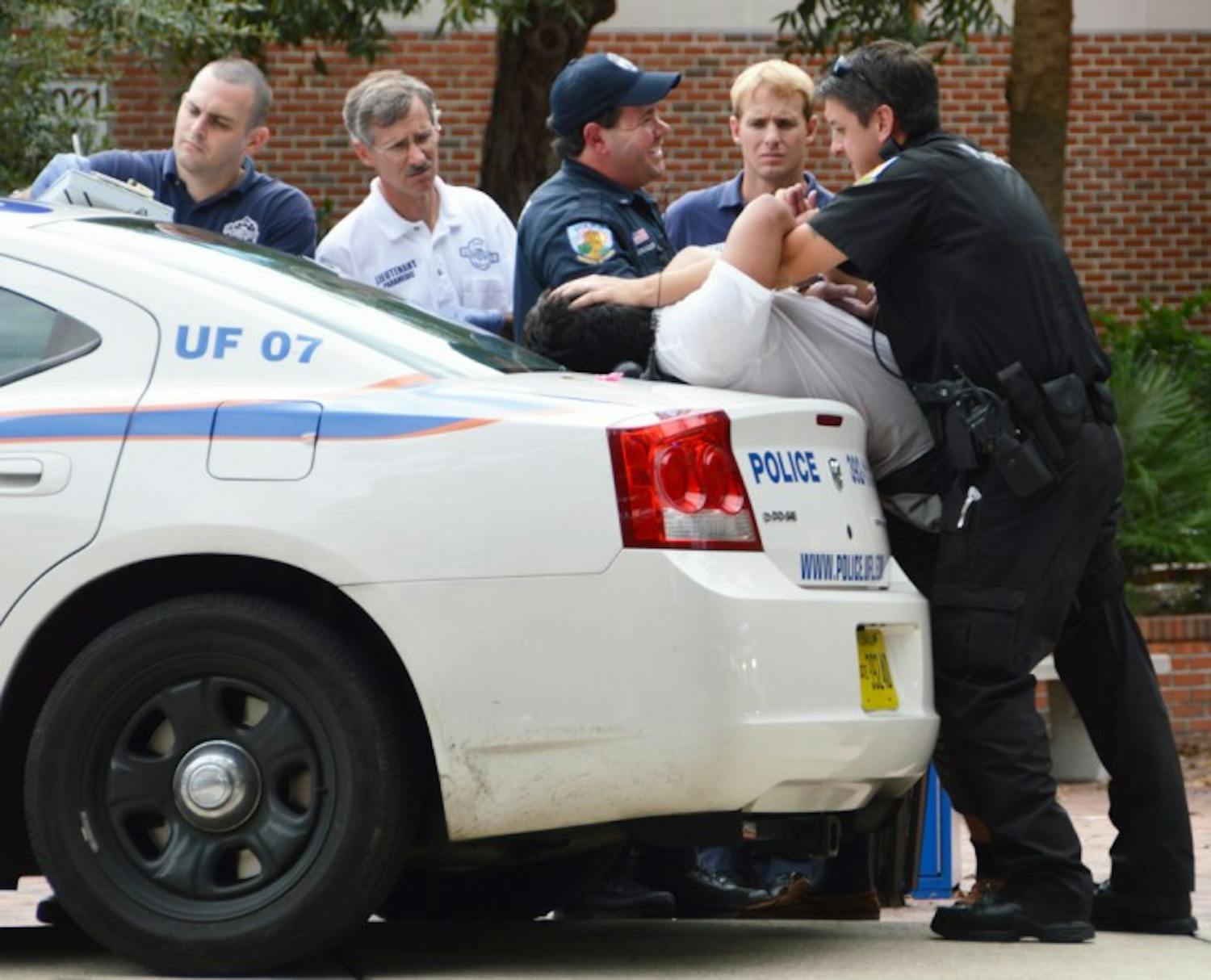 University Police officers arrest Alvaro Buenfil, 19, outside the Gator Corner Dining Center on Thursday. Police said Buenfil was under the influence of drugs at the time of his arrest.