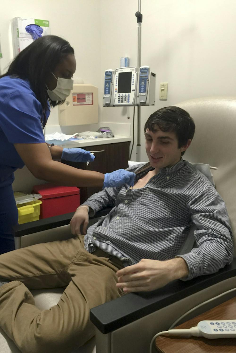<p>Daniel Ellis, a 22-year-old UF alumnus who graduated with a degree in business administration, waits as a nurse sterilizes an IV port during his fifth round of chemotherapy. In early December, Ellis was diagnosed with Hodgkin’s lymphoma.</p>