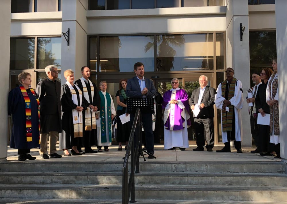 Mayor Lauren Poe calls on a crowd of 30 people to denounce hate speech and anti-semitism Tuesday afternoon outside of City Hall. When one person is harmed, it takes a toll on everyone, he said. 
