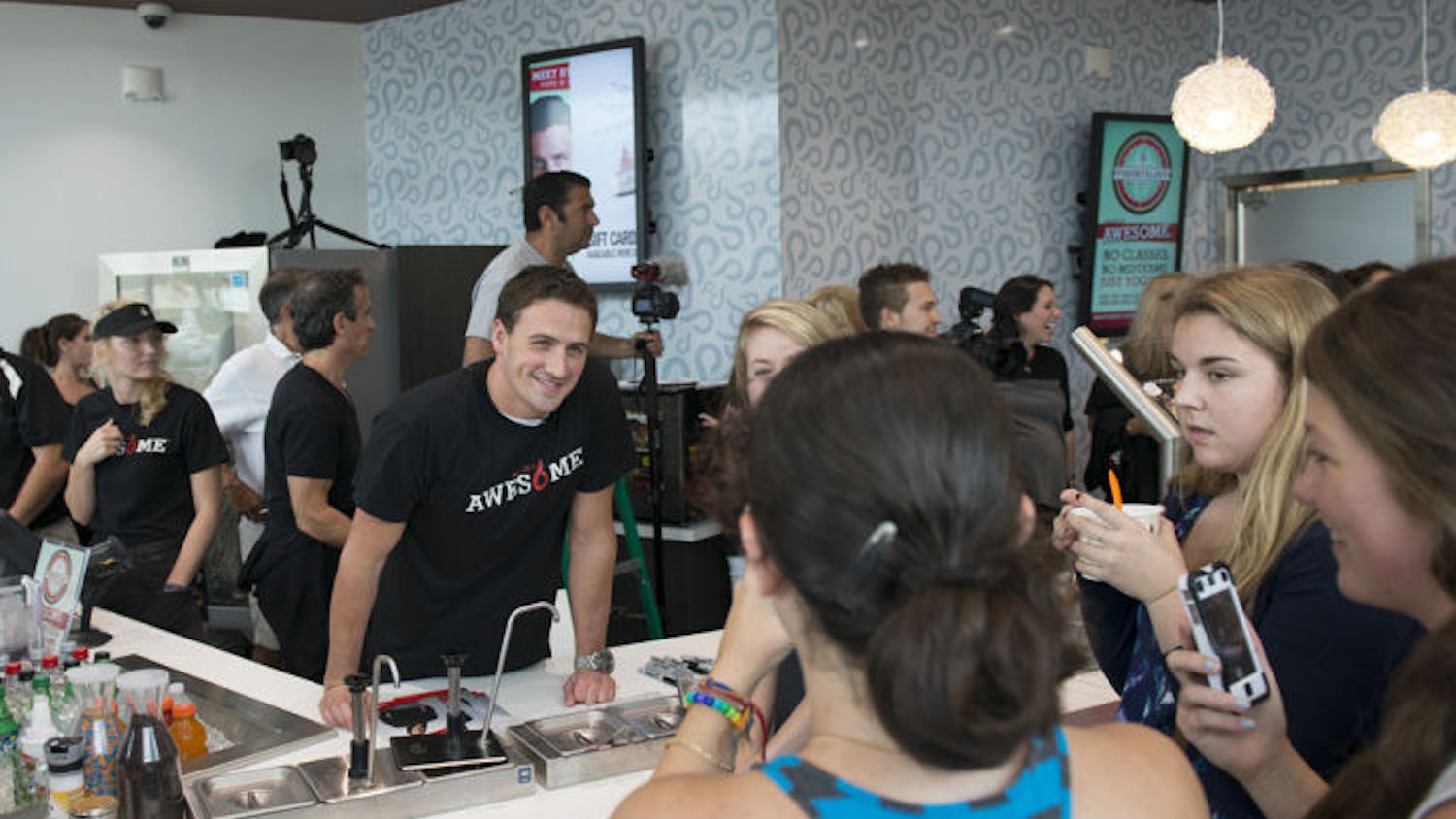 Ryan Lochte helps serve frozen yogurt to visitors at Yogurtology, 3730 Southwest Archer Road, on Saturday. The Olympic medalist partnered with the franchise to help raise money for charities he supports such as the Mac Crutchfield Foundation and Parent Project Muscular Dystrophy.