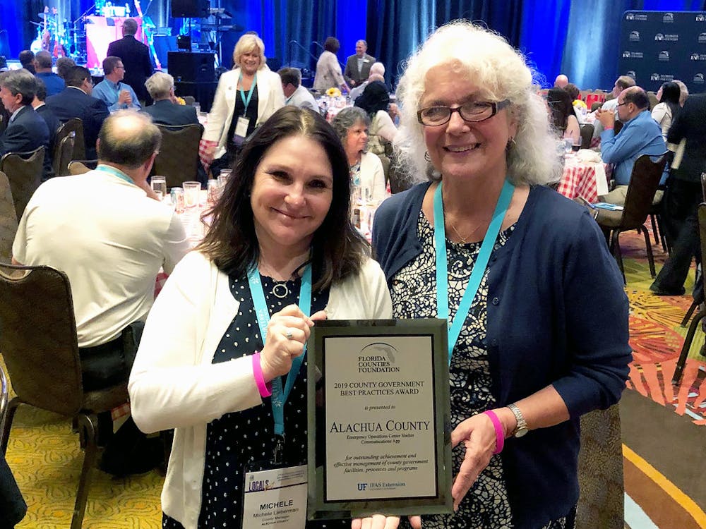 <p><span>County Commissioner Marihelen Wheeler (right) and County Manager Michele Lieberman (left) accept the award from&nbsp;</span><span><span>the Florida Counties Foundation at the Florida Association of Counties. Alachua was one of seven counties recognized at the ceremony</span></span></p>