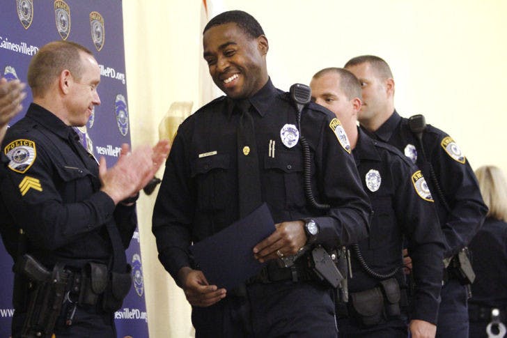 Gainesville Police Officer Warren Brown accepts an Award of Excellence during the Gainesville Police Department Awards Ceremony at Springhill Missionary Baptist Church on Thursday.