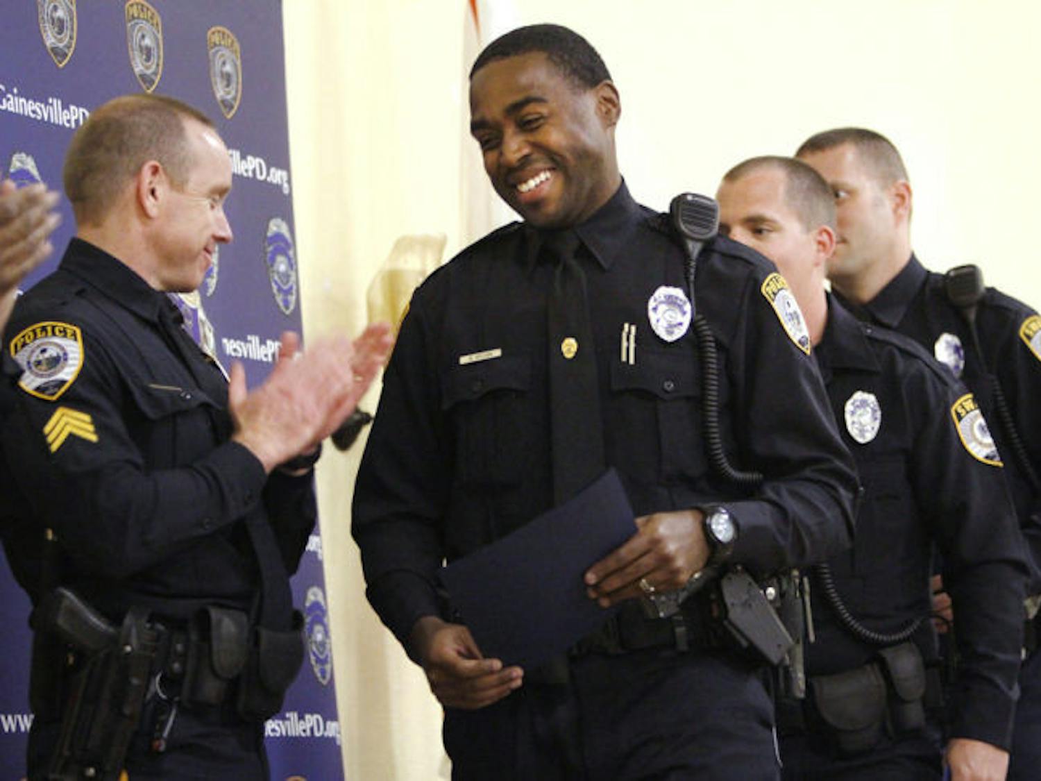 Gainesville Police Officer Warren Brown accepts an Award of Excellence during the Gainesville Police Department Awards Ceremony at Springhill Missionary Baptist Church on Thursday.