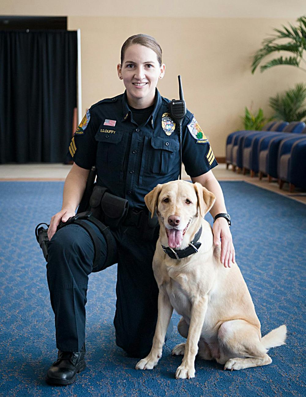 <p>Sergeant Ellen Duffy poses with her 4-year-old lab, Amber, one of the dogs expected to receive a free exam during the American College of Veterinary Ophthalmologists’ National Service Dog Eye Exam event at the UF Small Animal Hospital.</p>