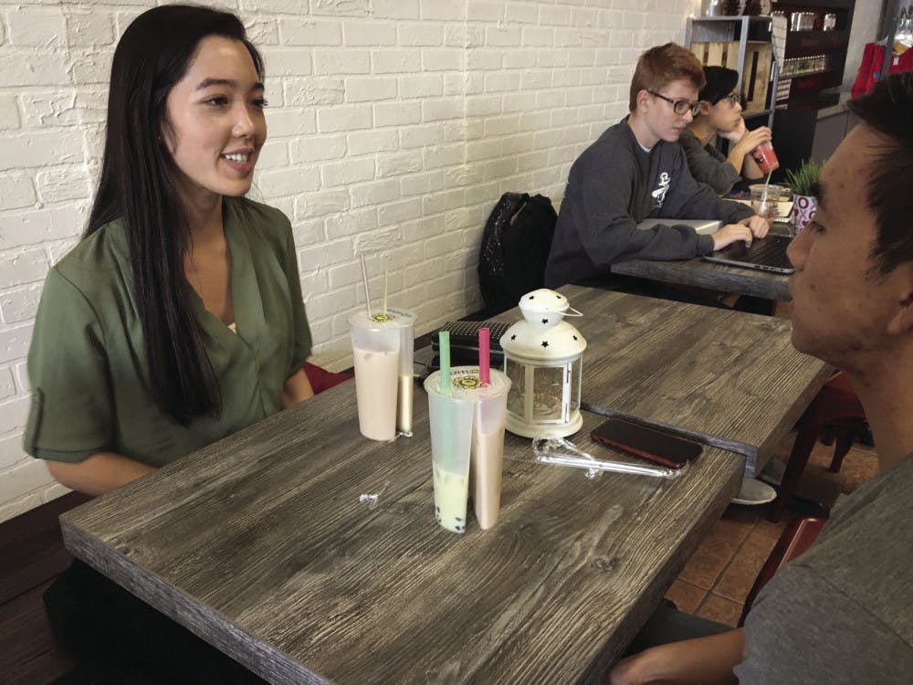 Anh Le, 24, a UF pharmacy graduate student, drinks a new Split-Cup tea with her friend Peter Duong, 23, a UF information systems and operations management graduate student. Le tried the jasmine and hazelnut Split-Cup milk teas, while Duong tried a matcha with boba and 1988 milk tea Split Cup.