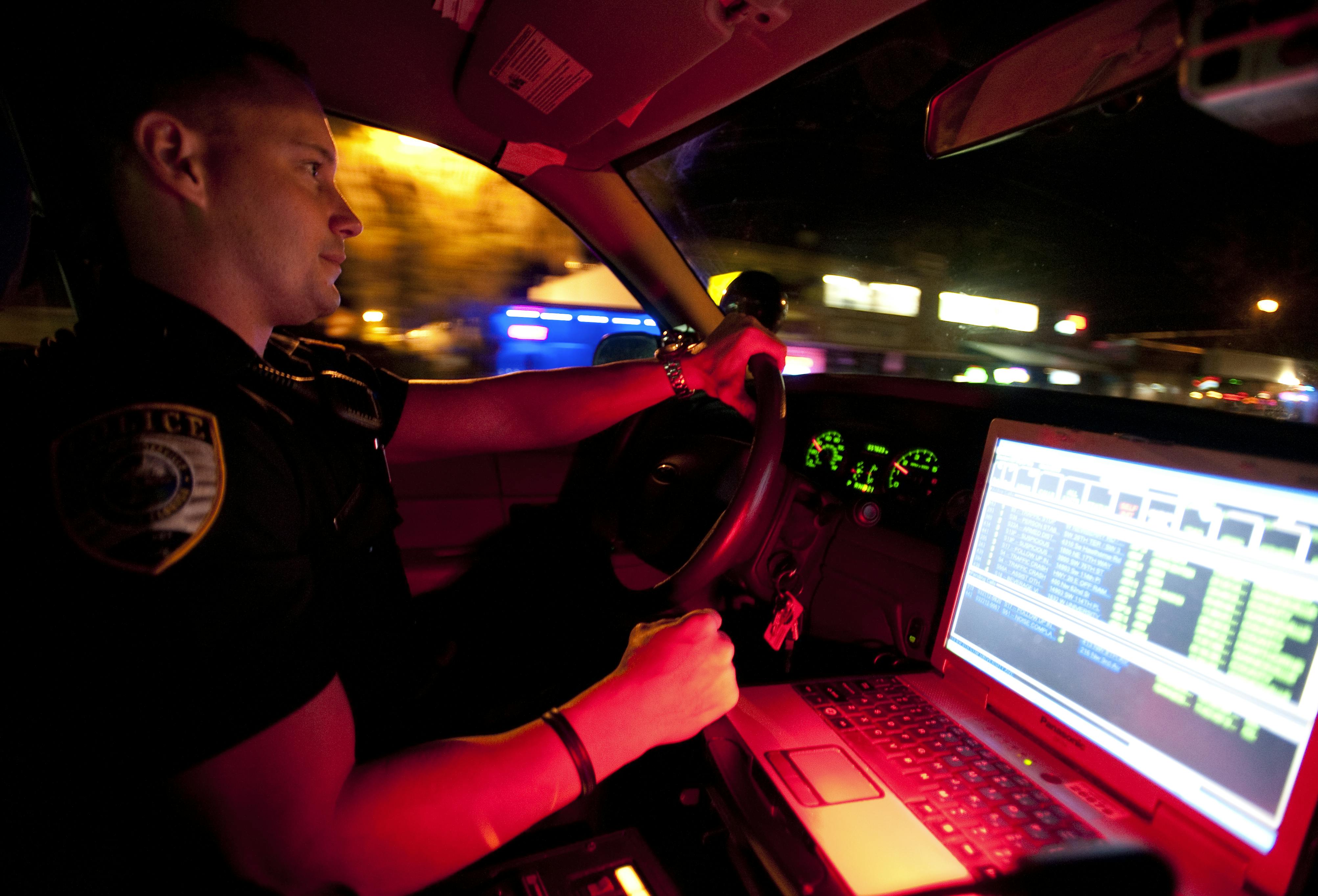 Gainesville Police officer Thomas Harrison drives his cruiser down University Avenue early Thursday morning.