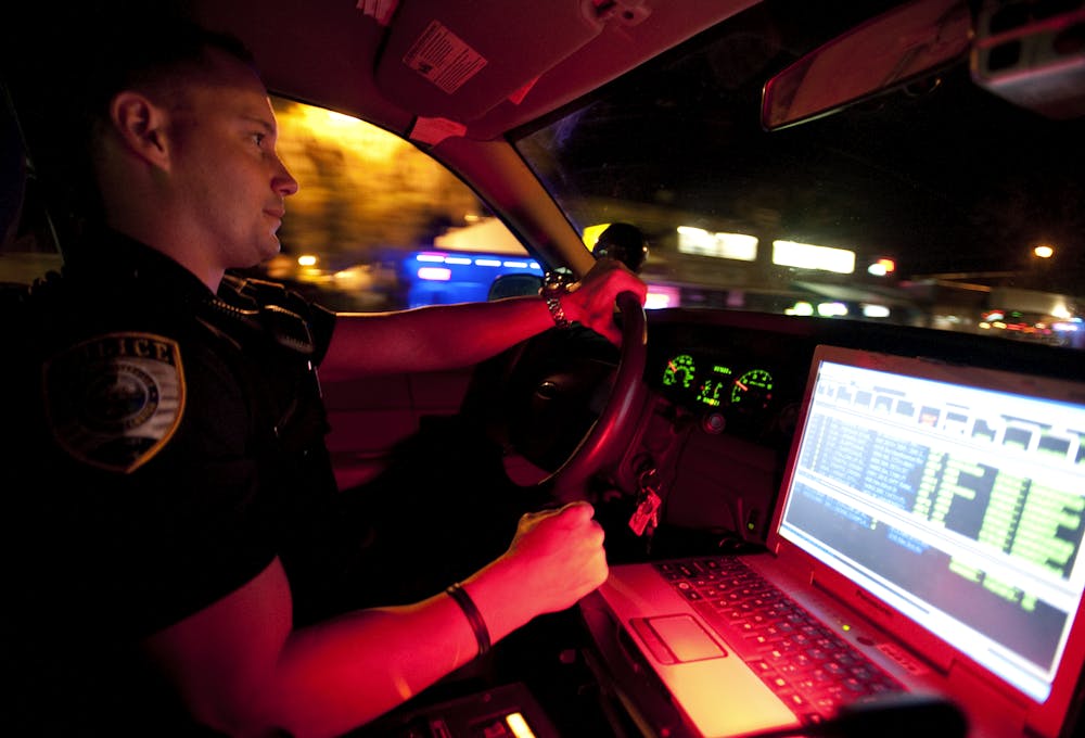 <p>Gainesville Police officer Thomas Harrison drives his cruiser down University Avenue early Thursday morning.</p>