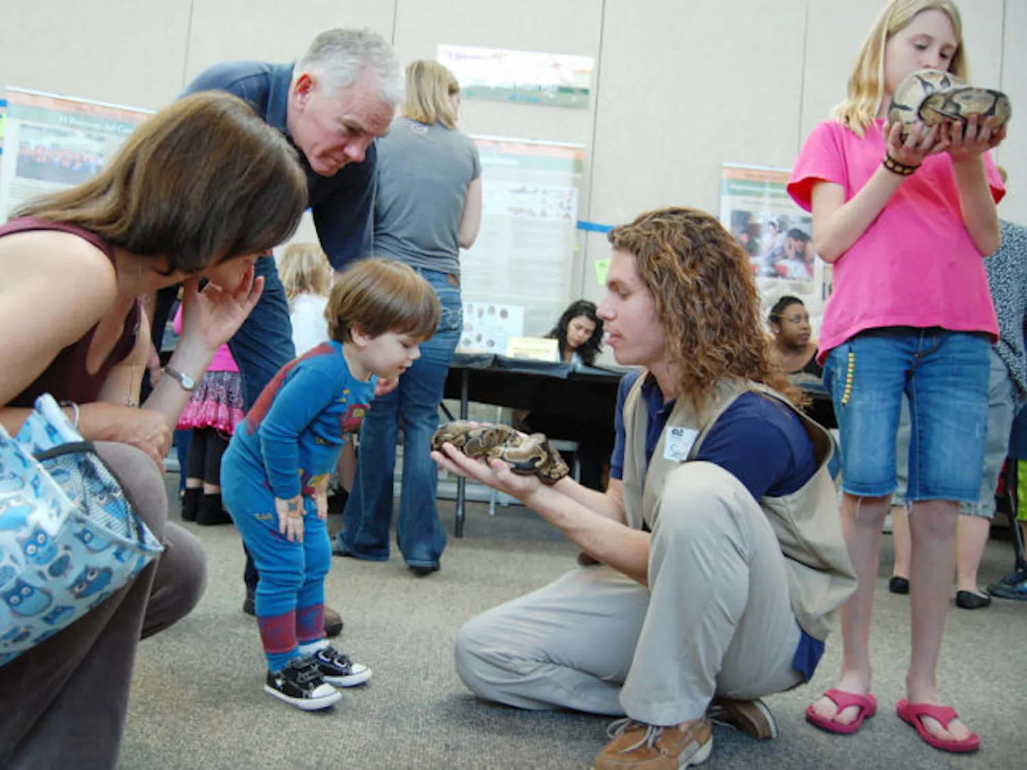 Wildlife ecology and conservation freshman Sean Tupper, 19, holds out a ball python snake to visitors at the Florida Museum of Natural History Saturday afternoon as part of their exhibit Titanoboa: Monster Snake.