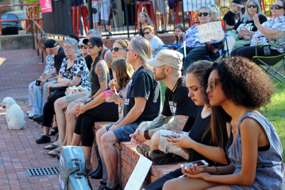 A line of people sit while listening to the speaker at the What Makes a President rally at Bo Diddley Plaza on Monday. The total crowd topped out at around 50, and there were chants such as "protect the press" and "release your taxes."